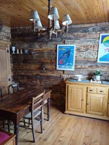 ein Esszimmer mit einem Tisch und Holzwänden in der Unterkunft La Cabane des 2 Sœurs (chalet 4-6 personnes) in Les Ougiers