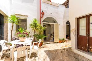 a patio with a table and chairs and plants at L'angolo Fiorito in Ugento