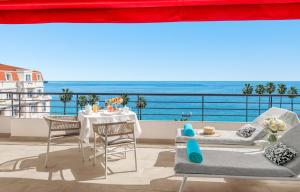 a balcony with a table and chairs and the ocean at Hôtel Barrière Le Majestic Cannes in Cannes