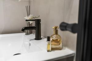 a bathroom sink with a bottle of soap on it at The APARTMENTS Company- Frogner in Oslo