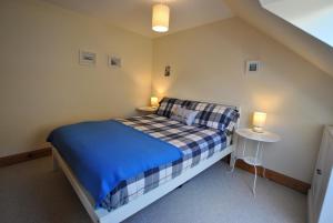 ein kleines Schlafzimmer mit einem Bett und zwei Tischen in der Unterkunft 2a Rose St- cosy coastal cottage Fife in Saint Monance