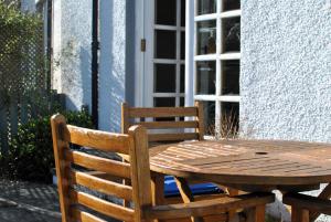 einen Holztisch und Stühle neben einem Fenster in der Unterkunft 2a Rose St- cosy coastal cottage Fife in Saint Monance