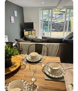 a wooden table with plates and wine glasses on it at The Hideout in Trearddur