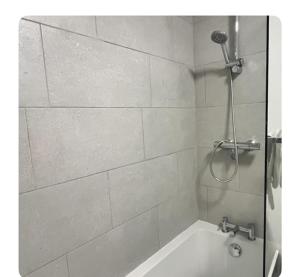 a bathroom with a shower and a bath tub at The Hideout in Trearddur