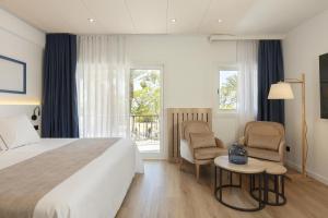Hotel Rovira في كامبريلس: غرفة فندقية بسرير وطاولة وكراسي