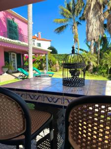 een vogelkooi op een tafel voor een huis bij Casa Caboz in Ponta do Sol