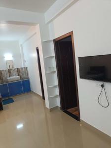 ein Wohnzimmer mit einer Tür und ein Zimmer mit einem TV in der Unterkunft Akbar Cottages in Anachal