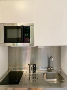 una cucina con lavello e microonde di Studio-Majno a Milano