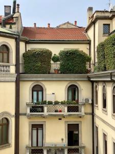 un edificio con balcone e piante sopra di Studio-Majno a Milano