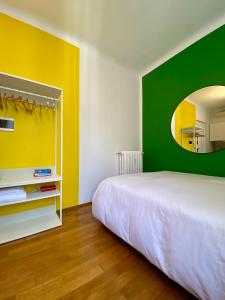 una camera con un letto bianco e una parete verde di Studio-Majno a Milano Altre 7 foto