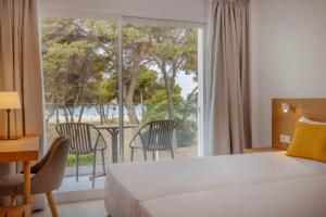 ein Hotelzimmer mit einem Bett und einem großen Fenster in der Unterkunft whala!isabela in Santa Ponsa