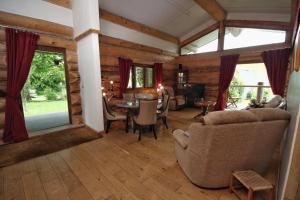 a living room with a table and chairs in a cabin at Log Cabin, Easter Hall Park in Petrockstow