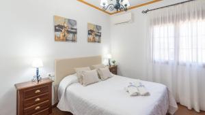 a bedroom with a bed with two shoes on it at Casa Tere Antequera - La Higuera by Ruralidays in Antequera +27 photos
