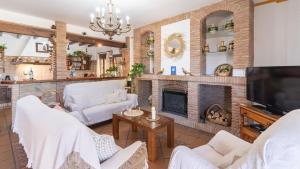 a living room with white furniture and a fireplace at Casa Tere Antequera - La Higuera by Ruralidays in Antequera