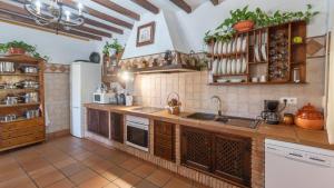 a large kitchen with wooden cabinets and appliances at Casa Tere Antequera - La Higuera by Ruralidays in Antequera
