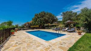 a swimming pool in a yard with chairs and a fence at Casa Tere Antequera - La Higuera by Ruralidays in Antequera