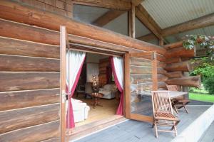 an open door of a wooden house with a patio at Log Cabin, Easter Hall Park in Petrockstow