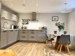 a kitchen with a table and a table and chairs at 1-BedCottage ModrnKitchen CarCharging Tv Wifi in Coleford +8 photos