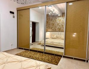 Una habitación con una pared de espejos y una cama dentro. en NEW Burgeois Berindey Apartment - Universitate, en Bucarest