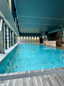 Una gran piscina con agua azul en un edificio. en TOMALE-AMT Apartamenty Kasprowicza Kołobrzeg - basen, jacuzzi, sauna, siłownia w cenie apartamentu, en Kołobrzeg