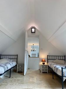 ein Schlafzimmer im Dachgeschoss mit 2 Betten und einer Uhr an der Wand in der Unterkunft Superbe Moulin - Château Landon in Château-Landon