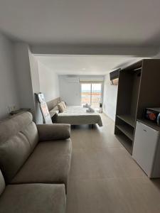 a living room with a couch and a bed at Brisa del mar Primera linea de playa in Puerto de Mazarrón