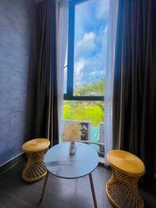 a table and two chairs in front of a window at MIS HOSTEL Cần Thơ in Can Tho