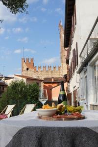 a table with a plate of food and a bottle and glass at Casa Clarita - in centro storico in Marostica