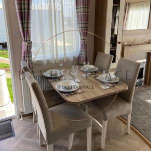a dining room table with chairs and a table with wine glasses at David's place at Tattershall lakes in Tattershall +8 photos
