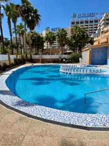 duży niebieski basen z palmami i hotel w obiekcie 1ra Linea Playa Magic World Luxury Apartament PP3 Pet w mieście Oropesa del Mar
