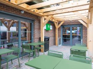 un patio avec des tables et des chaises dans un restaurant dans l'établissement ibis Styles London Gatwick Airport, à Crawley