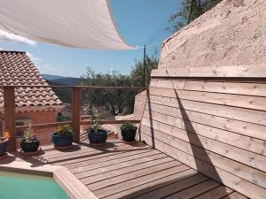 a wooden deck with potted plants next to a swimming pool at Villabellevie Bargemon Var in Bargemon