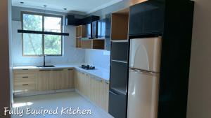 a kitchen with a white refrigerator and a window at Royal Lodge By Hotel Demanchi in Murree +29 photos