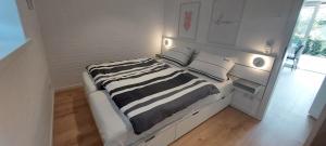 a white room with a bed with pillows at Bungalow 2243 in Tossens in Butjadingen