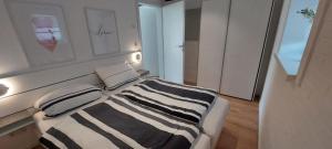 a bedroom with a bed with a black and white striped blanket at Bungalow 2243 in Tossens in Butjadingen