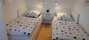 two beds in a small room with white at Bungalow 2243 in Tossens in Butjadingen +13 photos