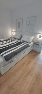 a white bed in a room with a wooden floor at Bungalow 2243 in Tossens in Butjadingen