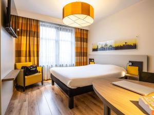 a hotel room with a bed and a desk at ibis Styles Hotel Brussels Centre Stéphanie in Brussels