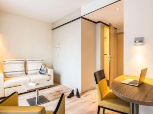 a living room with a table and a couch at ibis Styles Hotel Brussels Centre Stéphanie in Brussels