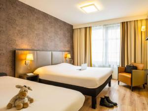 a hotel room with two beds and a teddy bear at ibis Styles Hotel Brussels Centre Stéphanie in Brussels
