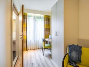 a small room with a table and a yellow chair at ibis Styles Hotel Brussels Centre Stéphanie in Brussels