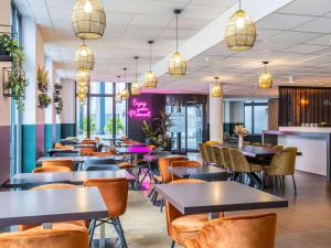 a restaurant with tables and chairs and lights at ibis Styles Hotel Brussels Centre Stéphanie in Brussels