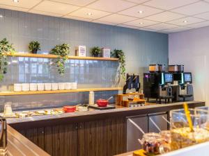 a restaurant kitchen with a counter with food at ibis Styles Hotel Brussels Centre Stéphanie in Brussels