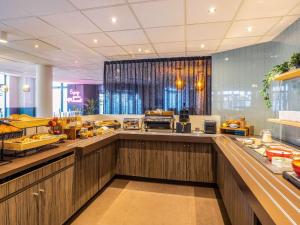 a buffet line in a restaurant with a lot of food at ibis Styles Hotel Brussels Centre Stéphanie in Brussels