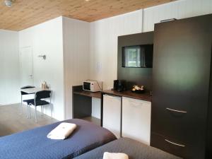 1 dormitorio con 1 cama y cocina con mesa en Telemark Motel and Apartment, en Hauggrend