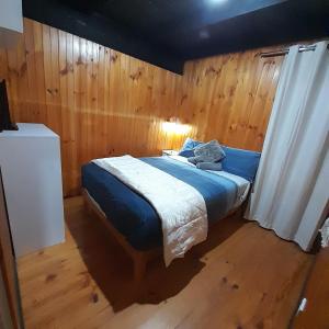 a bedroom with a bed with a wooden wall at Beachouse in Lock Sport