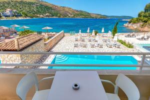a balcony with a table and a view of the ocean at Serenity House Kassiopi in Kassiopi
