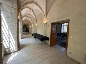 un couloir avec une table et des chaises dans un bâtiment dans l'établissement Hôtellerie Saint Yves, à Chartres