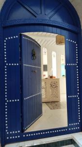 a blue door with a mirror in a room at Riad Al Manara in Essaouira