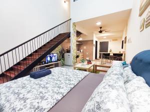 a living room with a large bed and a staircase at AZ Suites 1 @Putrajaya Cyberjaya in Cyberjaya